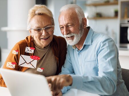 Senioren, die auf ihren Laptops Newsletter von dänischen Hotels erhalten
